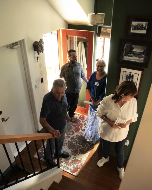 At one of the homes on the 15th-annual Idyllwild Home Tour, which the Idyllwild Area Historical Society sponsors, IAHS docent Pamela Fojtik (center) welcomes old Idyllwild friends Evan Mills (entering) and Charles and Carol Russell. Photo by John Drake 