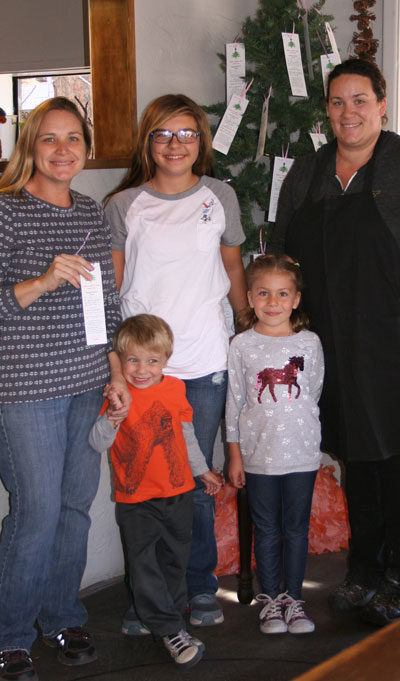The Idyllwild HELP Center has put up its annual angel trees. This one is located at Idyllwild Bake Shop and Brew, where owner Katie White (right) helped Colleen Meyer (left), executive director of the HELP Center, and her children Peyton, Brynnley and Caden decorate the tree. Two other trees can be found at the Idyllwild Library and Fairway Market. People are asked to take a child’s request from the tree, buy the item new and bring it to the HELP Center office unwrapped. Photo by JP Crumrine 