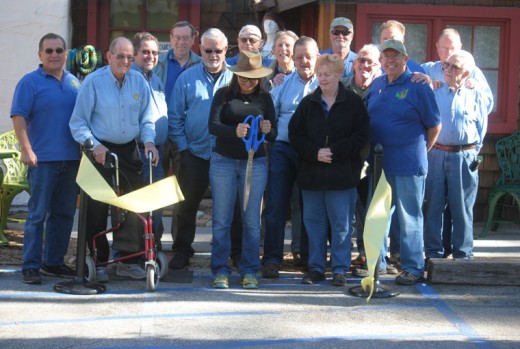 Cat Orlando (center), owner of Mountain Boho, where you find eclectic handmade treasures, cuts the Rotary ribbon. Rotarians at the cutting were (from left) Steve Espinosa, Charlie Wix, John Graham, Roland Gaebert, Terry Kurr, Chuck Weisbart, Dennis Dunbare, Ric Foster, Kathy Duncan, Thom Wallace, Craig Coopersmith, Christopher Scott, Jeffrey Cohen, Chuck Streeter and Earl Parker. Photo by JP Crumrine 