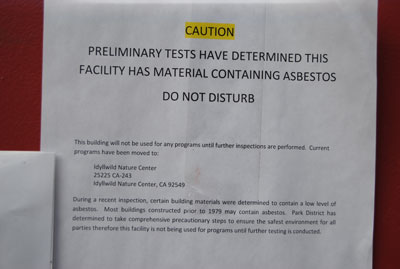 This notice, announcing the presence of some asbestos materials, was posted on the front door of Town Hall this weekend. Photo by JP Crumrine