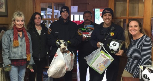 Riverside County Fire Department staff from Station 23 Pine Cove brought toys from their Spark of Love program to the Idyllwild HELP Center Monday. Here, from left, Nanci Killingsworth (president of the HELP Center board) and Skye Zambrana (client services administrator at the HELP Center), accept the gifts from the Station 23 staff, Rodger Hughes (engineer), Capt. Mark Gillman and Tyler Williams (engineer) and Colleen Meyer (executive director of the Idyllwild HELP Center). Photo by Julia Ledesma 