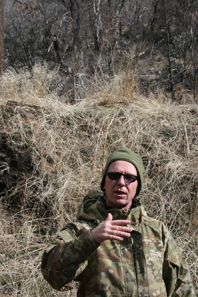 Yokoji-Zen Mountain Center Abbot Tenshin Fletcher, Roshi, stands before a wall of debris and explains the two-year work project to prepare the heavily mud- and debris- damaged center to withstand further rain onslaughts and the coming El Niño. 