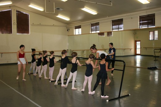 Young Idyllwild students are introduced to fixtures in any ballet class, the ballet barre and the mirrors. Here, Idyllwild Arts Academy Dance Department student teachers adjust their young charges’ feet for a specific balletic position. Currently, 38 local children, ages 3 to 12, are taking class on the Idyllwild Arts campus as part of the newly inaugurated Children’s Dance Program.Photo by Marshall Smith 