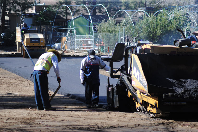Workers pave the new parking lot Shane Stewart created at the corner of North Circle Drive and Cedar Street.Photo by J P Crumrine
