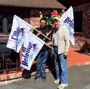 Pete Capparelli (right), of the Idyllwild Community Center, helped install three Idyllwild Community Center “I’M HELPING” flags for restaurant owner Luis Solis (left), who said he is thrilled to be in Idyllwild and to have ICC flags flying in front of all three of his restaurants — Jade Mountain, Fratello’s and The Lumber Mill. Photo courtesy Chris Trout