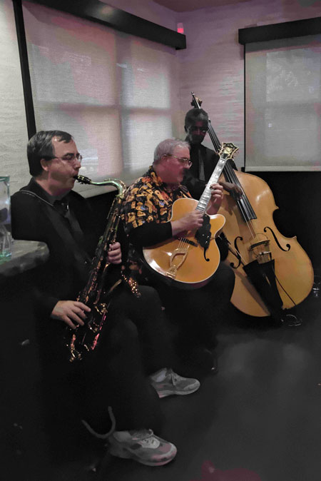 Forced inside because of the cool weather on Saturday evening, May 21, the Tom Hynes Jazz Trio still entertained Ferro diners. From left are Dan St. Marseille on sax, Hynes on guitar and Marshall Hawkins on bass, each very familiar to jazz fans in Idyllwild. They combined to present a welcome addition to patrons’ meals. Photo by Tom Kluzak 