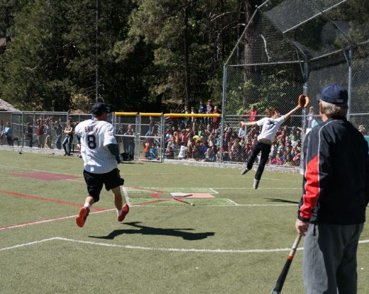 During the student and staff softball game Friday, May 27, the last day of school for 2015-16, phys ed teacher Darren  McKay scores at home as catcher Jaden Meskimen leaps to catch the throw home. Photo by Chandra Lynn