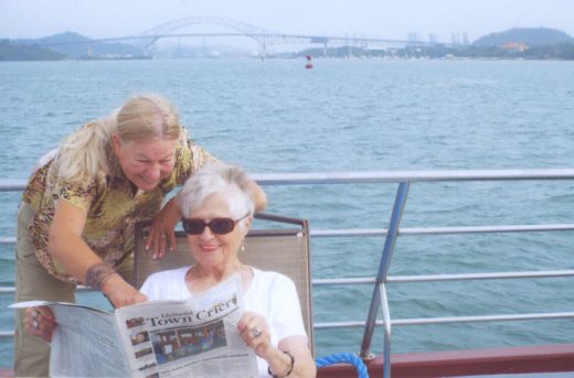 Elaine Hoggan of Pine Cove shares her Town Crier with daughter-in-law Janet while cruising toward the Bridge of the Americas en route to the Panama Canal. The newer, much larger canal opened the next day and made the canal transit extra interesting and historic. Photo by Jon Hoggan