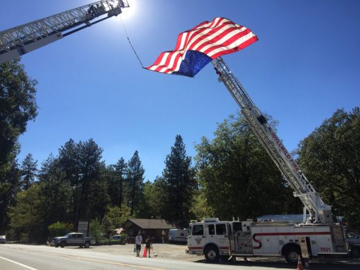 Idyllwild Fire and the Idyllwild Volunteer Fire Company set up their annual 9/11 tribute on Highway 243 Sunday afternoon. Idyllwild Fire Chief Patrick Reitz wrote, “As 9/11 falls on a Sunday we are encouraging everyone to spend this day with their families. IFPD will again show our respect to those whom made the ultimate sacrifice by flying Old Glory high and proud from our Ladder on T621. Please take a moment to say I love you to your loved ones & remember the families of all of those that died in and since as a result the terrorist attacks of September 11, 2001.” Photo by Jenny Kirchner 