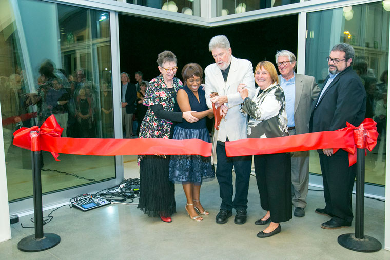 Saturday evening was the official opening of the William M. Lowman Concert Hall on the Idyllwild Arts campus. Cutting the red ribbon are (from left) Faith Raiguel, past chair of the board of governors; Pamela Jordan, president and head of school; William Lowman, past headmaster; Carolyn Lowman; Dwight “Buzz” Holmes and Jeffrey Dvorak, chair of the board of governors.  Photo by Jenny Kirchner
