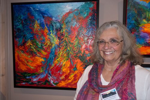 Jacque Swerdfeger stands in front of her art work during the “Art Uncorked — Afternoon with the Artist” show at Middle Ridge Winery Tasting Gallery on Saturday. Photo by Peter Szabadi