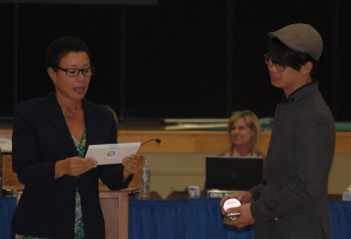 Dr. LaFaye Platter (left), deputy superintendent at Hemet Unified School District, read the recognition for Nam Park, who was the recipient of the district’s Good Apple Award for her volunteer service at Idyllwild School. Park could not attend the HUSD Oct. 4 board meeting at Idyllwild School, and her son, Jason, accepted the award on her behalf.   Photo by JP Crumrine 