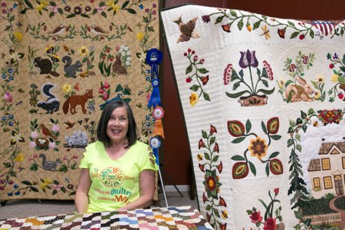 Billy Kercmer poses with her quilts. She was the featured quilter at the annual Mountain Quilters of Idyllwild Quilt Show on display at Buckhorn Camp over the weekend. Photo by Jenny Kirchner