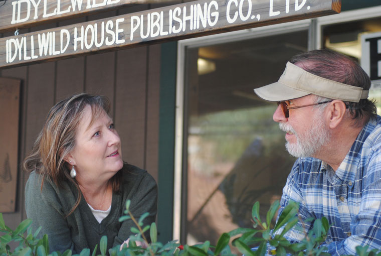 Becky and Jack Clark, co-owners and publishers of the Idyllwild Town Crier, celebrate the 70th anniversary of the paper’s founding in 1946. The first edition came out on Nov. 1, 1946. The Clarks are on the porch of the Town Crier’s sixth location in its 70 years of publication.	Photo by Marshall Smith