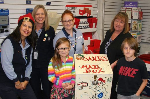 Hill kids can now post their letters to Santa in a special mailbox in the customer service section of the U.S. Post Office at Idyllwild. Post office employees (from left) Christina Reitz, Sherry Kaufman, Kelsi Lehman and Kelly Gates show Evelyn Johnson, 9, and Carter Johnson, 10, where the letters go. By special arrangement with Santa, the Town Crier will be permitted to open the box so kids’ letters to Santa can be published in the Dec. 22 newspaper. Letters need to be in the box by Saturday, Dec. 17, one week before Christmas. Photo by Jack Clark 