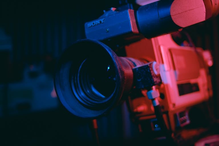 Artistic close-up of a vintage video camera lens in dramatic lighting.