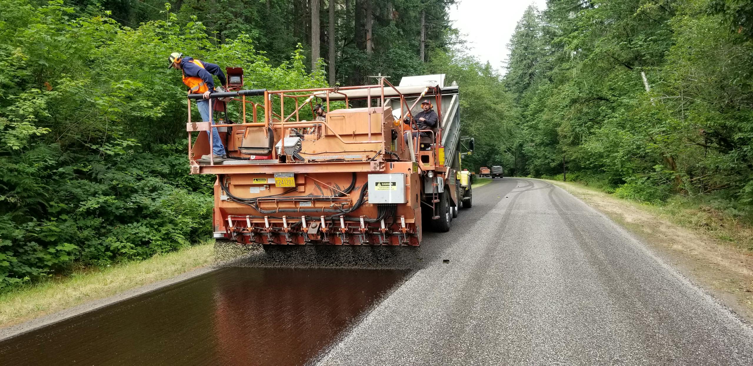 Chip seal process being applied to a rural road in Vida, Oregon.