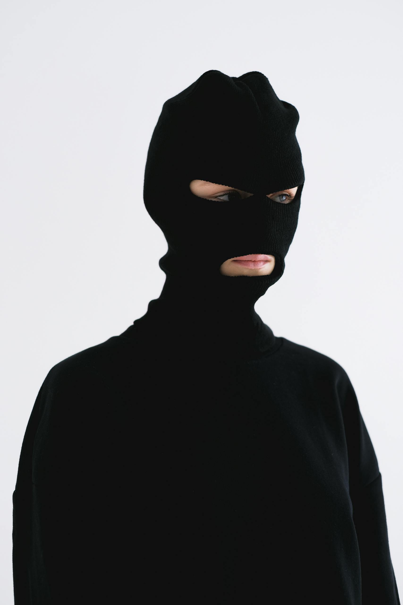 Mysterious individual wearing a black balaclava, evoking anonymity and intrigue.