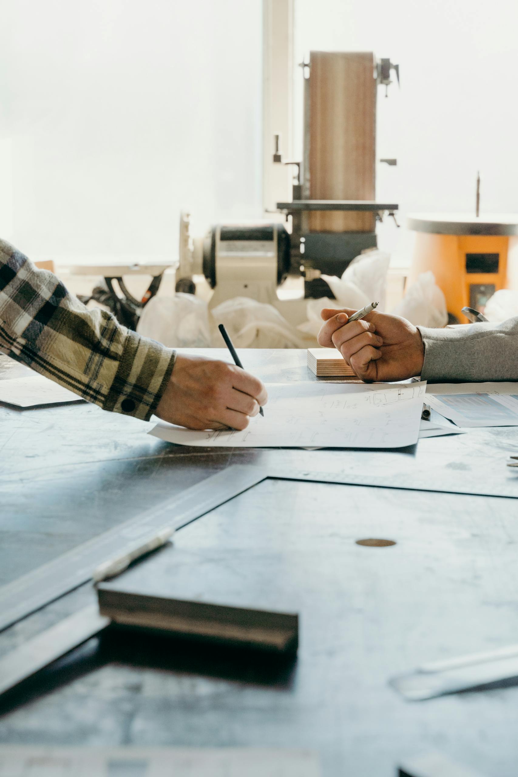 Two people in a workshop writing and collaborating on documents.