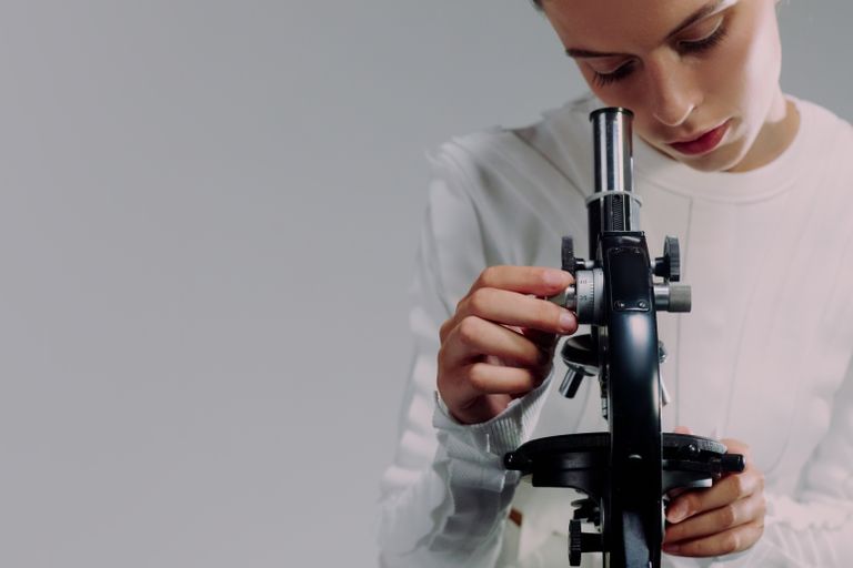 A scientist carefully examining samples using a microscope in a modern laboratory setting.