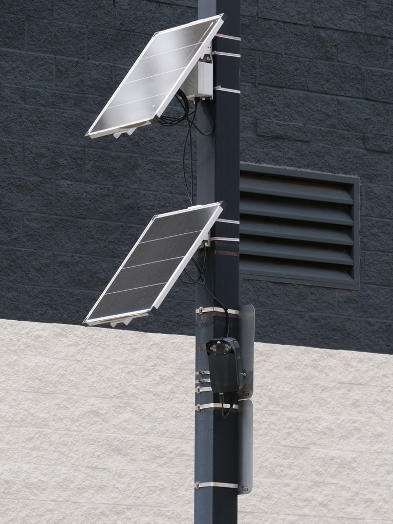 Solar panels and camera mounted on a pole for smart city surveillance.