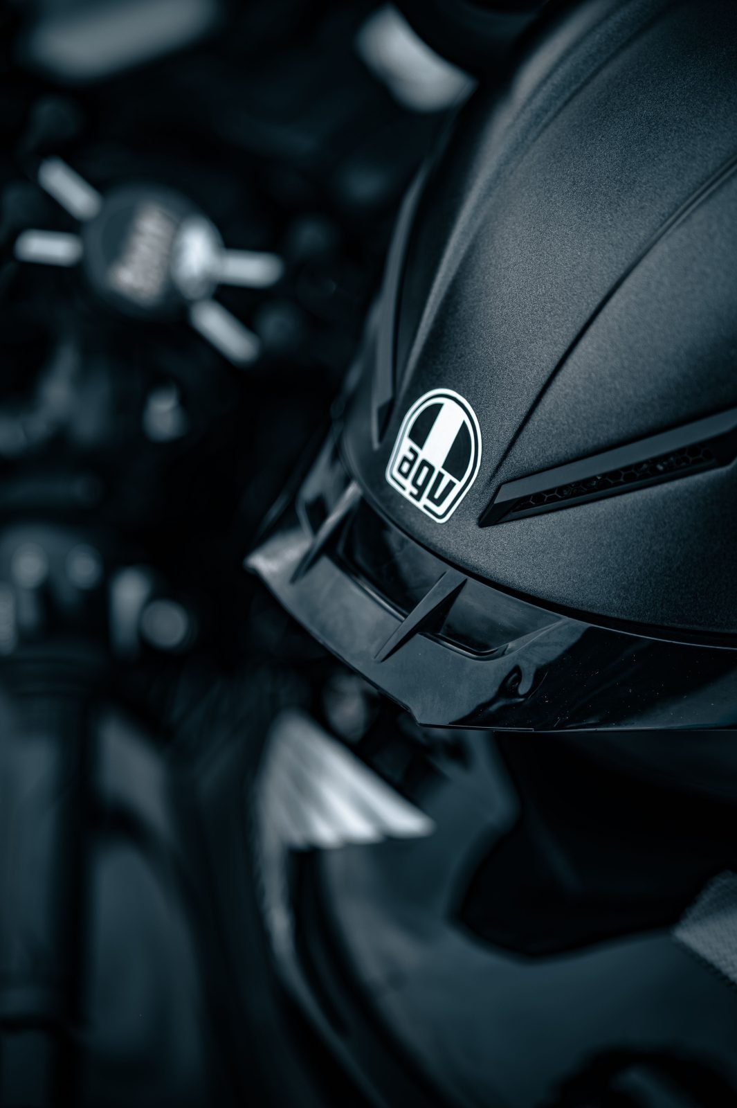 Stock photo for illustration: Detailed image of a sleek black motorcycle helmet and part of a motorcycle.